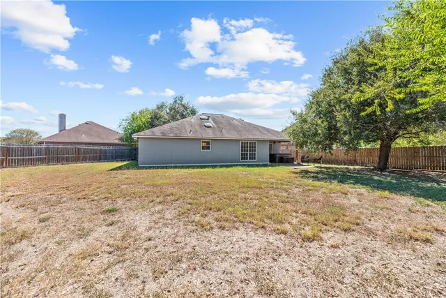 a front view of house with garden space and trees