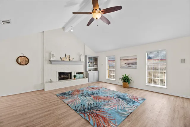 a view of an empty room with a window and fireplace