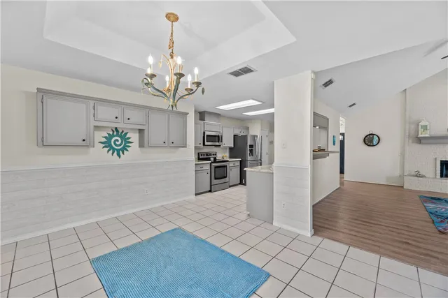 a view of a kitchen with kitchen island a counter top space appliances and cabinets