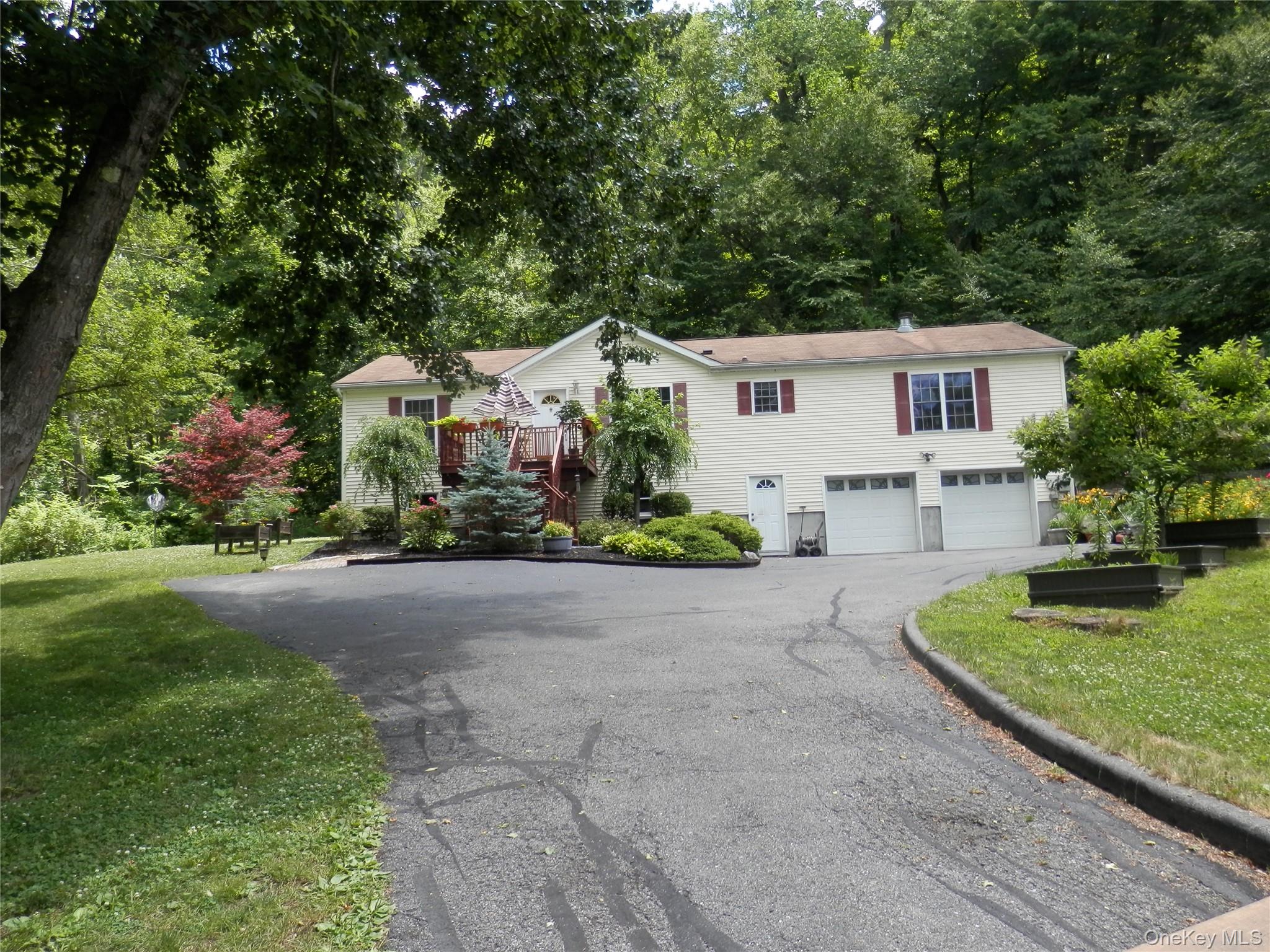 590 Farm To Market Road Brewster, NY 10509 - Photo 7 of 32 a front view of a house with a garden and trees