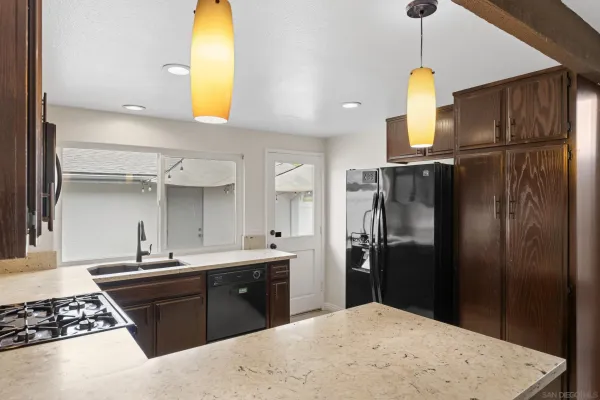 a kitchen with a sink stainless steel appliances a refrigerator and cabinets