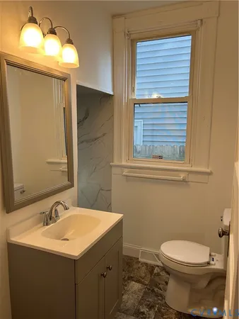 a bathroom with a toilet sink and mirror