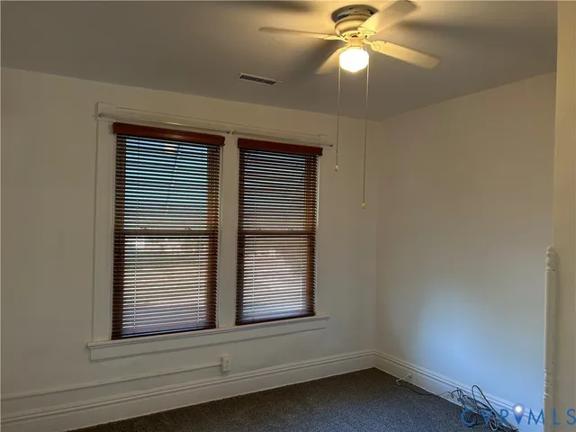 a view of wooden floor and a chandelier fan in a room