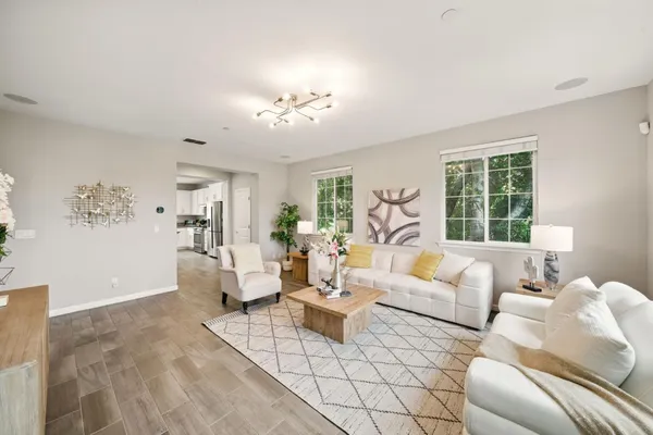 a living room with furniture chandelier and a large window