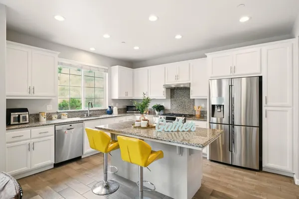 a kitchen with stainless steel appliances granite countertop a refrigerator sink and cabinets