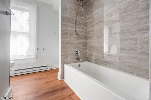 a bathroom with a bathtub and next to a window