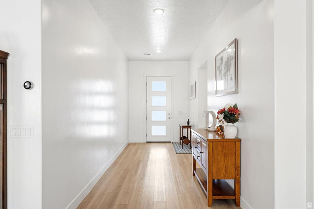 5963 Flattop Drive St. George, UT 84790 - Photo 5 of 45 Bright entryway featuring light wood-finish flooring, recessed lighting, a modern entry door with frosted glass panels, and a smart thermostat