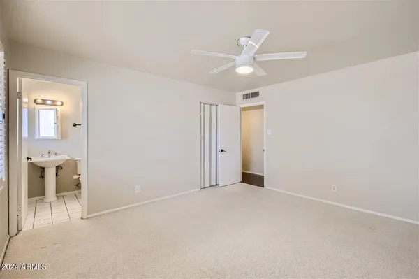 an empty room with closet and fan