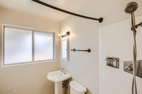 a bathroom with a sink toilet and mirror