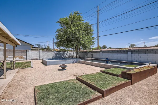 a view of a backyard with chairs and potted plants