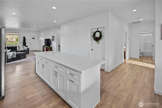 a kitchen with stainless steel appliances a white stove top oven and a refrigerator with white cabinets