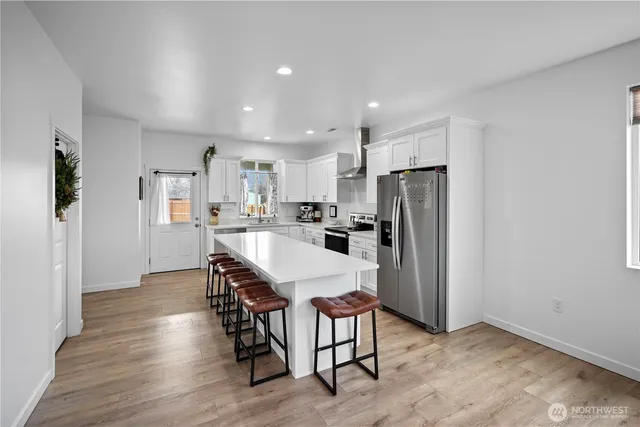 a kitchen with kitchen island wooden cabinets and refrigerator