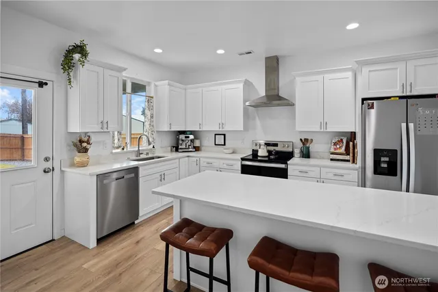 a kitchen with white cabinets and stainless steel appliances