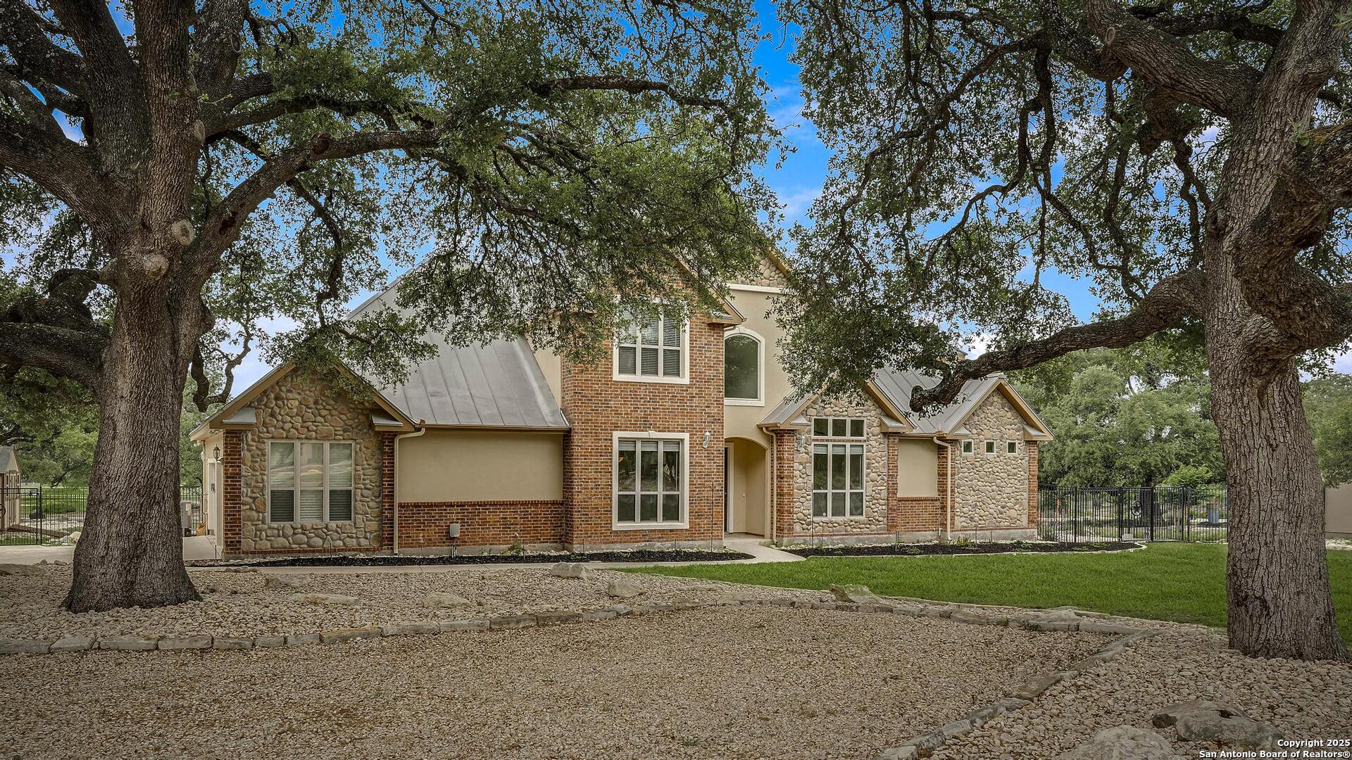 a view of a yard in front of a house with large trees