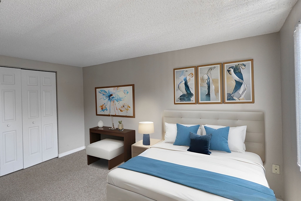 8 9th Street, Unit 406 Medford, MA 02155 - Photo 12 of 21 a bedroom with a bed and a couch