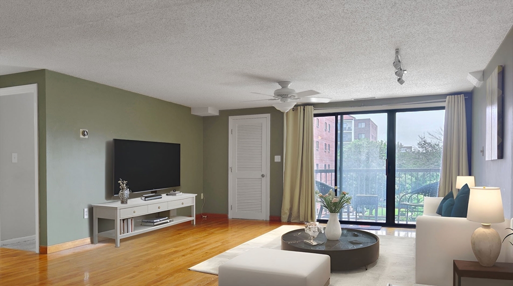 8 9th Street, Unit 406 Medford, MA 02155 - Photo 3 of 21 a living room with furniture and a flat screen tv