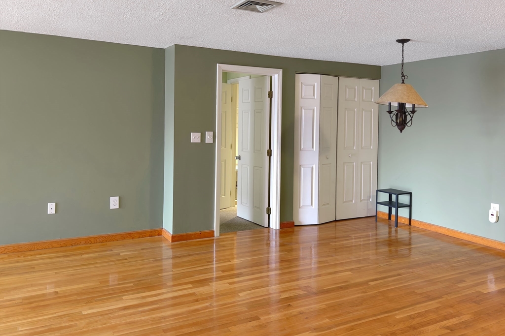 8 9th Street, Unit 406 Medford, MA 02155 - Photo 5 of 21 a view of an empty room with wooden floor and a window
