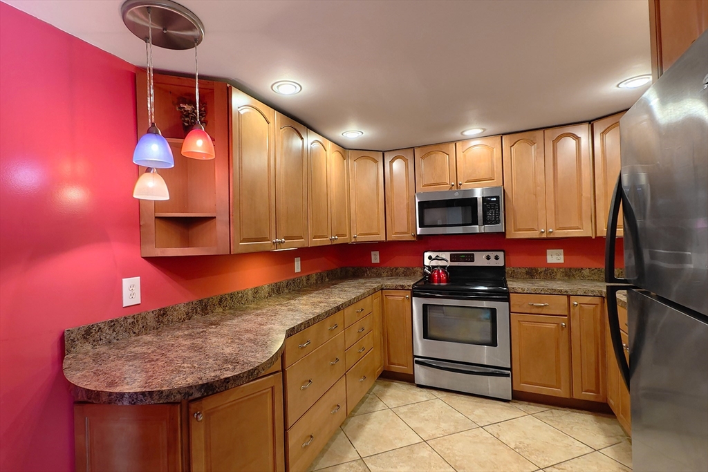 8 9th Street, Unit 406 Medford, MA 02155 - Photo 6 of 21 a kitchen with stainless steel appliances granite countertop a sink and a stove