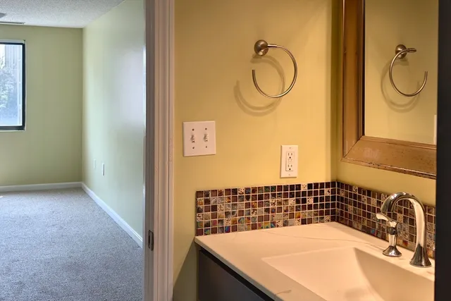 a bathroom with a granite countertop sink and a mirror