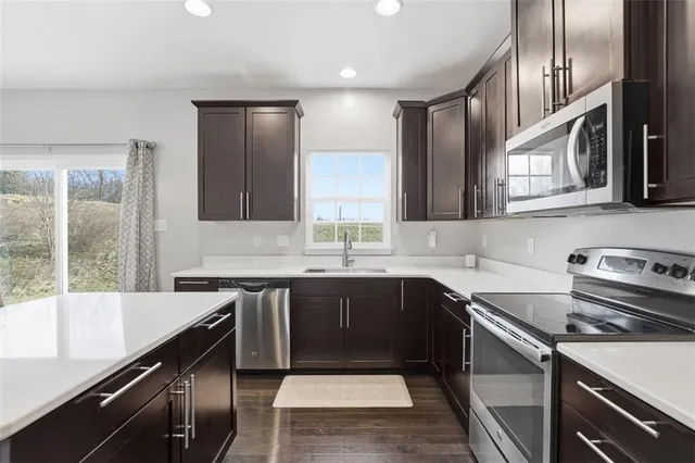a kitchen with stainless steel appliances granite countertop a sink stove and refrigerator