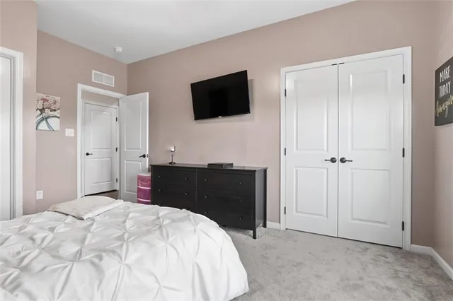 a bedroom with a bed and a flat tv screen in it