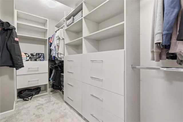 a view of walk in closet with clothes and shoes