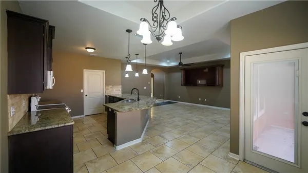 a open kitchen with a sink and a refrigerator