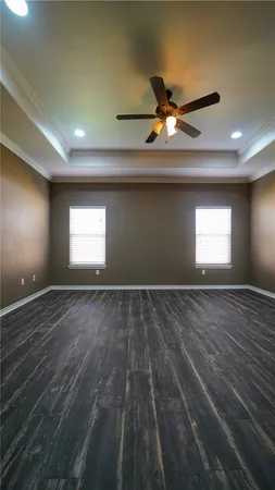 a view of empty room with window and ceiling fan
