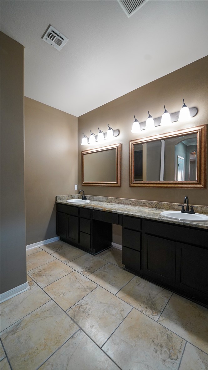6809 Summer Wind Drive Corpus Christi, TX 78413 - Photo 16 of 27 a spacious bathroom with a double vanity sink and a mirror