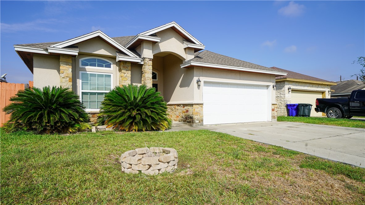 6809 Summer Wind Drive Corpus Christi, TX 78413 - Photo 2 of 27 a front view of a house with a yard and garage