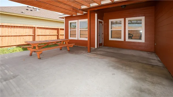 a backyard of a house with barbeque oven table and chairs