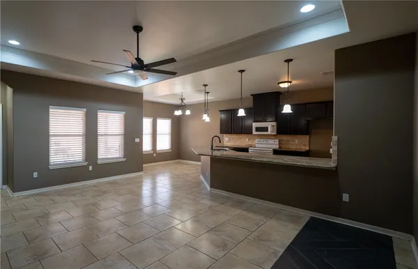 a large room with chandelier fan and windows