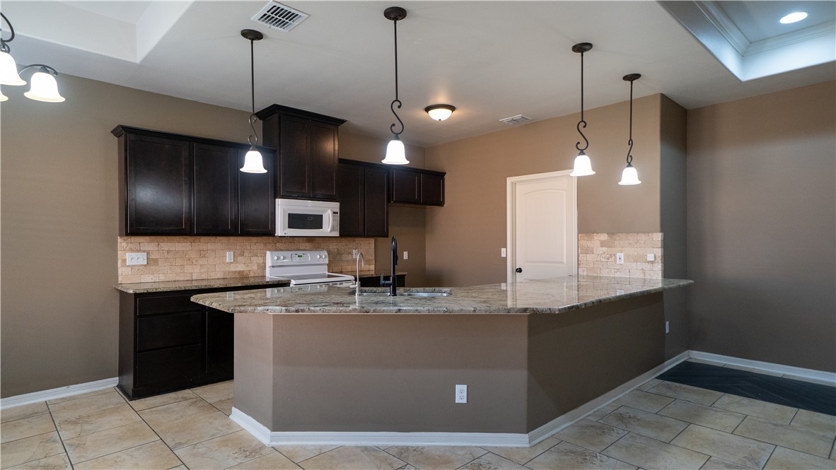 6809 Summer Wind Drive Corpus Christi, TX 78413 - Photo 7 of 27 a kitchen with kitchen island a sink stainless steel appliances and a chandelier