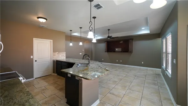 a view of a kitchen with a sink and refrigerator