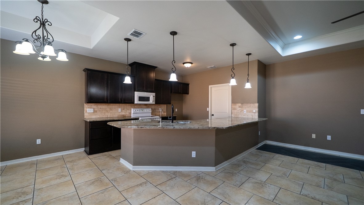 6809 Summer Wind Drive Corpus Christi, TX 78413 - Photo 10 of 27 a kitchen with kitchen island a sink stainless steel appliances and a chandelier
