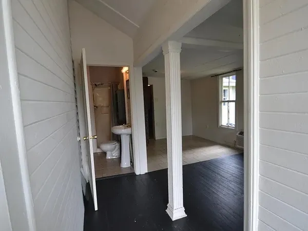 a view of a hallway with wooden floor and closet area