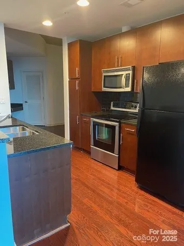 a kitchen with stainless steel appliances granite countertop a refrigerator and a stove