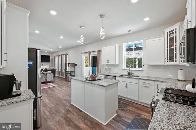 a kitchen with stainless steel appliances granite countertop sink stove top oven and cabinets