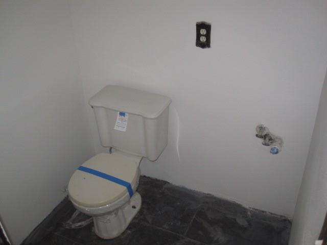 2150 Harris Street Gainesville, TX 76240 - Photo 13 of 20 a white toilet sitting next to a bathroom sink