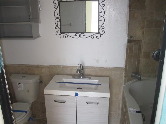 2150 Harris Street Gainesville, TX 76240 - Photo 7 of 20 a bathroom with a sink a toilet and mirror