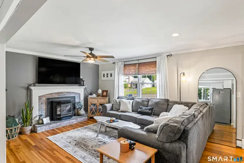 a living room with furniture a flat screen tv and a fireplace