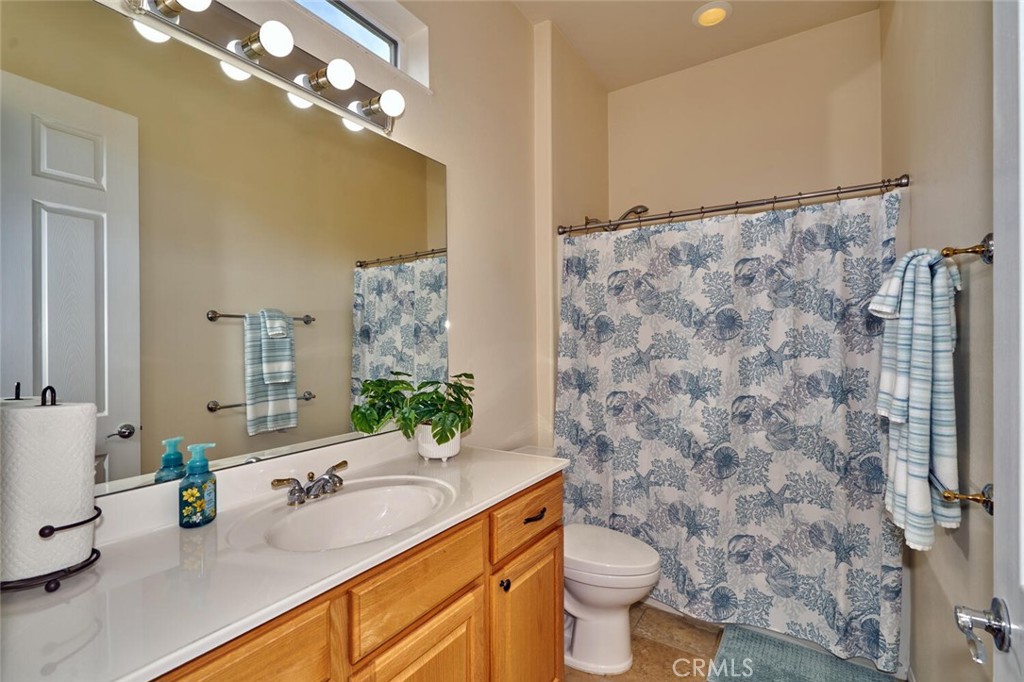 860 Annandale Road Beaumont, CA 92223 - Photo 32 of 61 a bathroom with a granite countertop sink a toilet a mirror and shower curtain