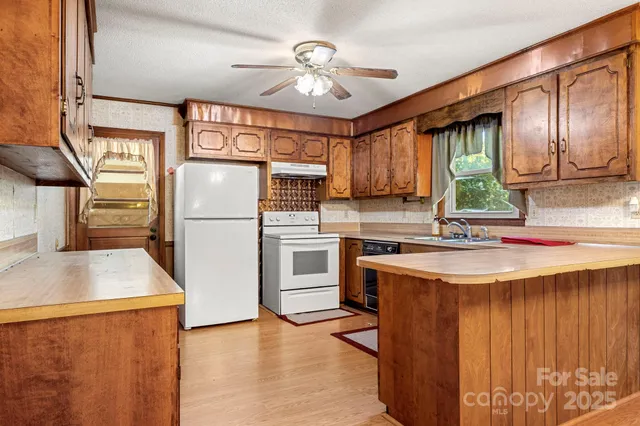 a kitchen with stainless steel appliances a refrigerator a sink and a stove