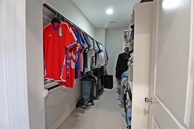 a view of walk in closet with clothes