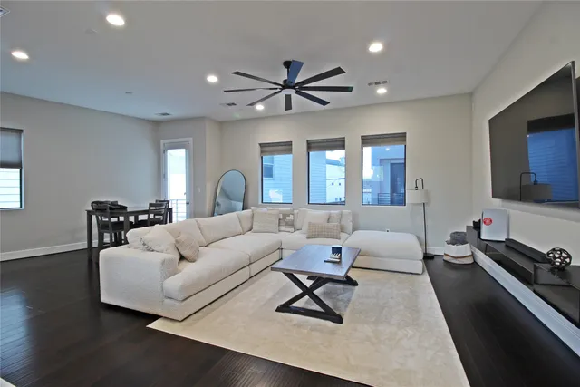 a living room with furniture and a flat screen tv with wooden floor