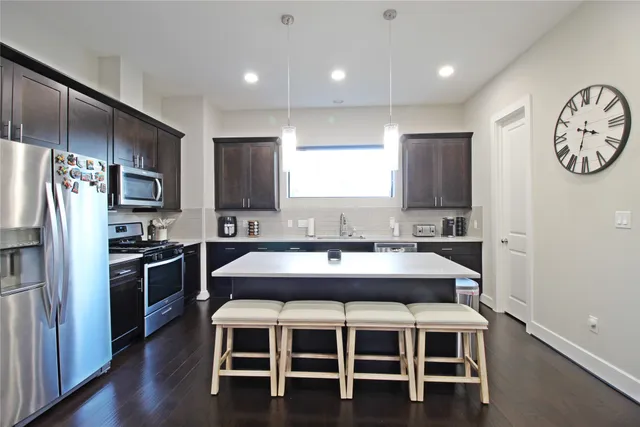 a kitchen with kitchen island a dining table and stainless steel appliances