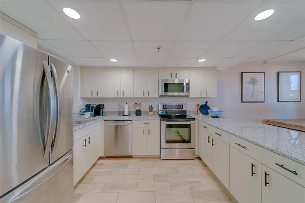 a kitchen with appliances a refrigerator and a sink