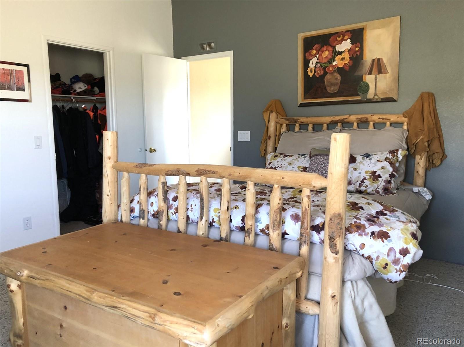 1983 Arapahoe Road Hartsel, CO 80449 - Photo 20 of 39 a bedroom with a bed and a painting on the wall