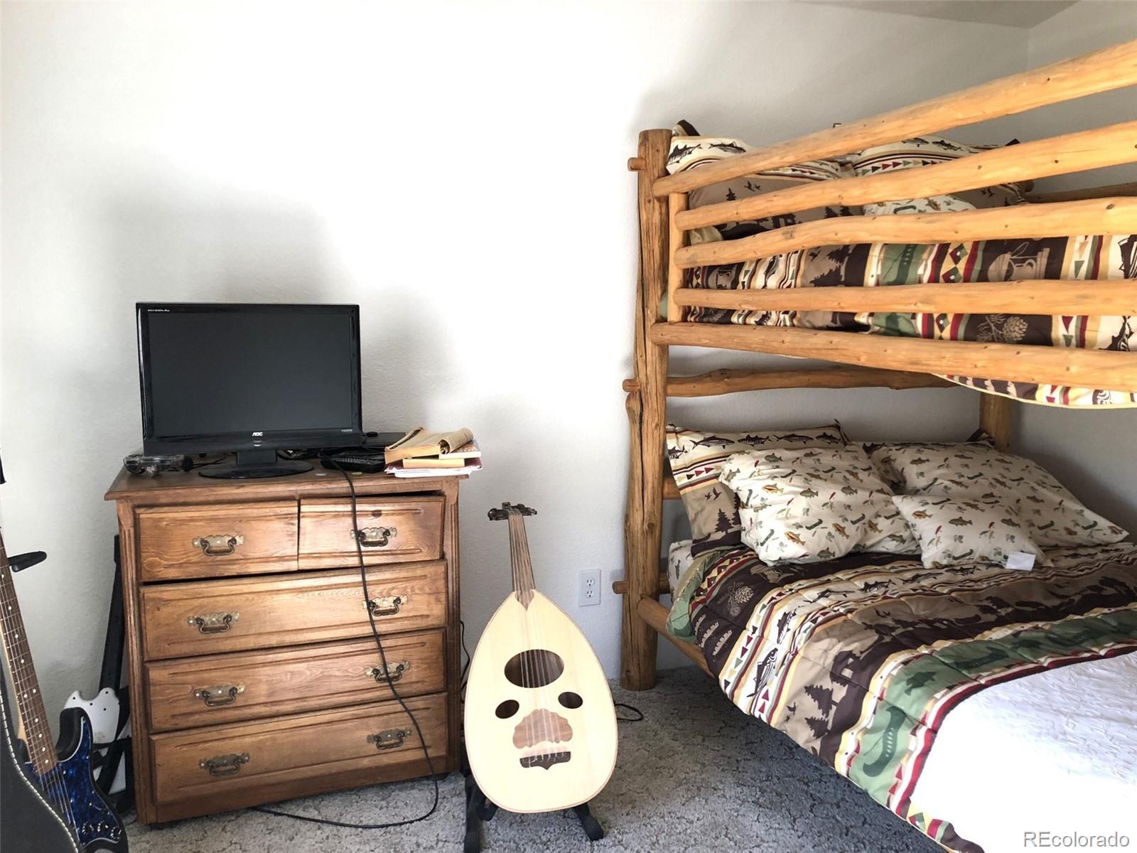 1983 Arapahoe Road Hartsel, CO 80449 - Photo 23 of 39 a bed sitting in a bedroom and a flat screen tv