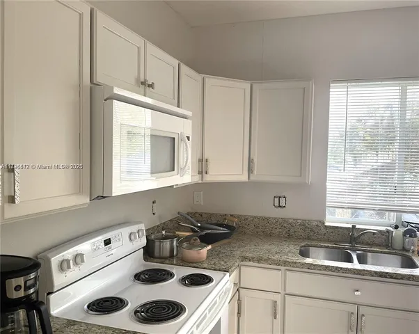 a kitchen with a sink a stove a microwave and cabinets